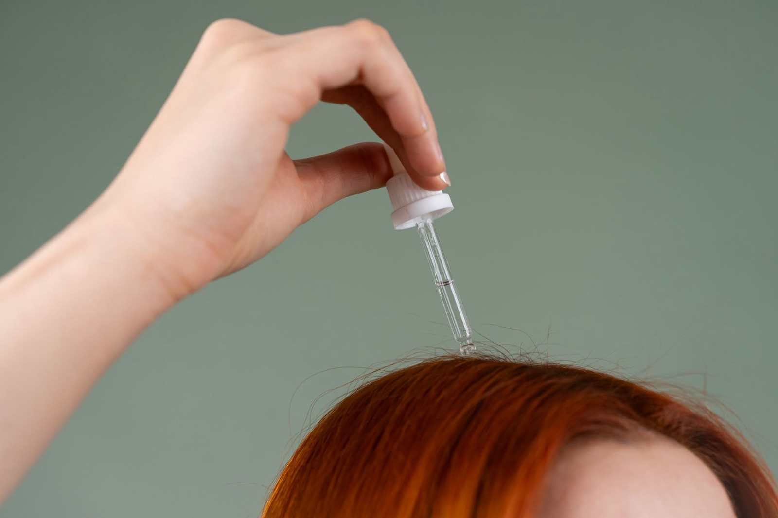 Scalp serum being applied to the part line